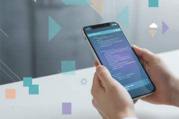 Smartphone showing app development with code interface